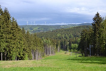 V dáli se tyčí stožáry větrných elektráren (IČ)