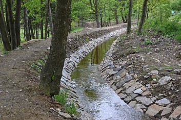 Dlouhá stoka. Místo, kde voda teče do kopce (stojíme proti proudu). (IČ)