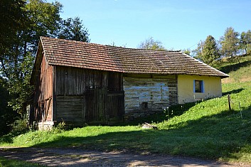Tady snad opravdu někdo bydlí. Na okně je truhlík s květinou. (IČ)